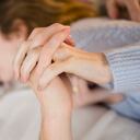 Couple holding hands while kissing