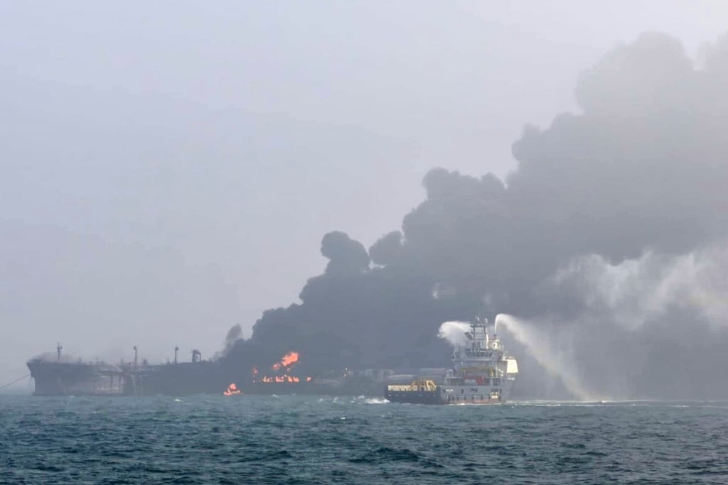Esta imagen proporcionada por Bartek Śmiałek muestra un barco que intenta extinguir el fuego mientras se elevan columnas de humo desde un buque de carga después de que un buque cisterna que transportaba combustible para aviones chocara contra un petrolero que transportaba combustible para aviones en la costa este de Inglaterra el lunes 10 de marzo de 2025, provocando el incendio y el desbordamiento de combustible hacia el Mar del Norte. (Bartek Śmiałek vía AP)