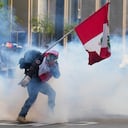 Un simpatizante del destituido presidente Pedro Castillo devuelve un contenedor de gas lacrimógeno en dirección a la policía, 12 de diciembre de 2022, en Lima, Perú. Castillo afronta un pedido de extender su prisión preliminar de 7 días a 18 meses. (AP Foto/Martin Mejia)