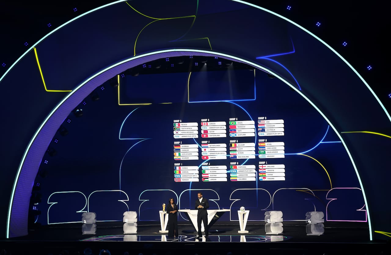 La leyenda de la FIFA Rio Ferdinand y la codirectora Samantha Johnson hablan mientras la pantalla muestra el sorteo final durante el sorteo oficial de la Copa Mundial de la FIFA 2026 en el Centro John F. Kennedy.