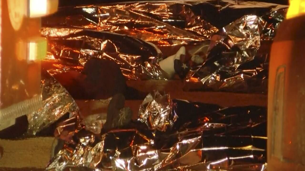 Imagen tomada de un video que muestra cuerpos tendidos bajo sábanas plateadas afuera de un centro de inmigración en Ciudad Juárez, México, el martes 28 de marzo de 2023.