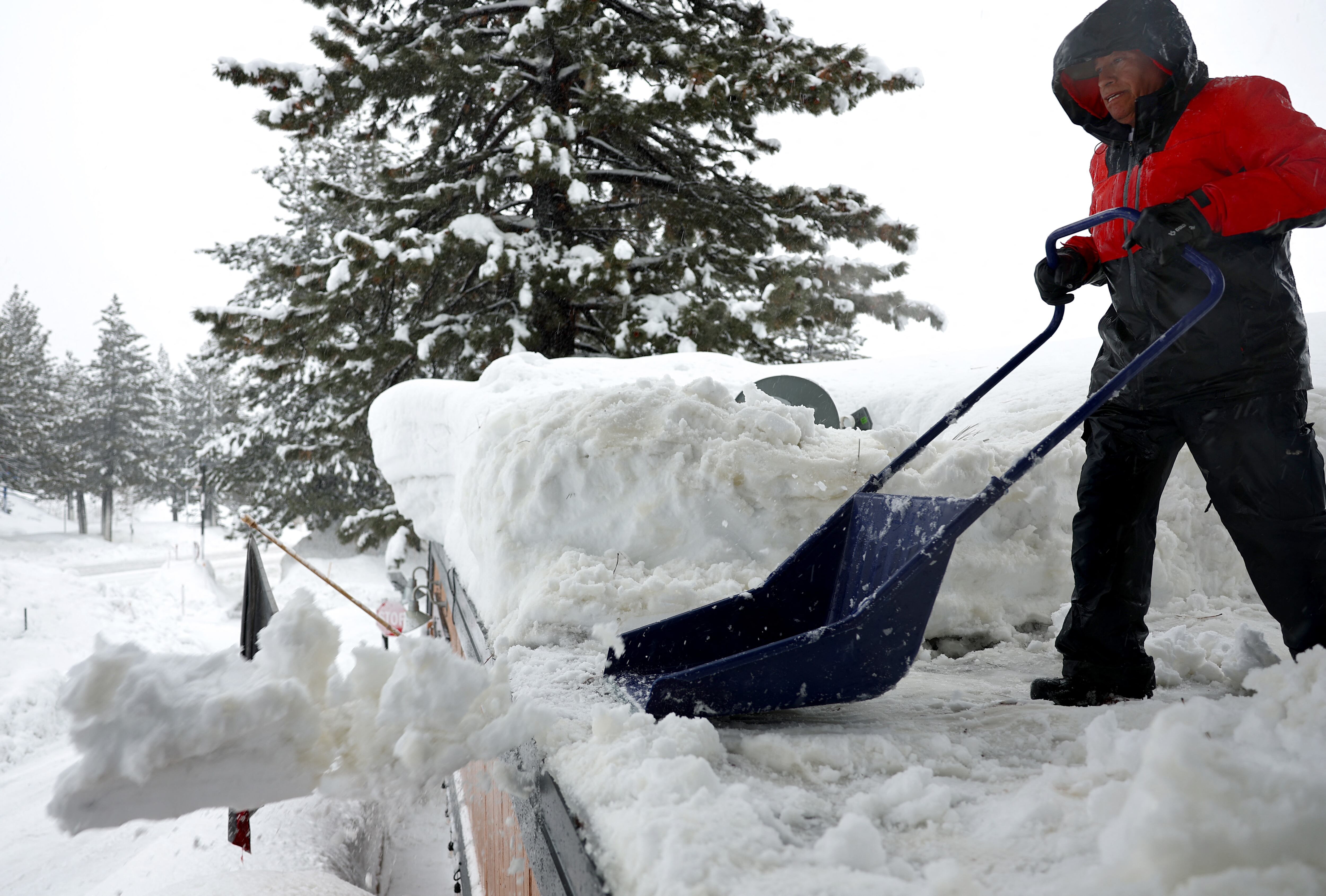 Un trabajador limpia la nieve del techo de un negocio durante otra tormenta de invierno en las montañas de Sierra Nevada el 10 de marzo de 2023 en Mammoth Lakes, California. Las montañas de Sierra Nevada de California están siendo golpeadas por fuertes nevadas en elevaciones más altas, lo que eleva aún más los niveles de la enorme capa de nieve. Las comunidades de las montañas que aún se están recuperando de tormentas anteriores en elevaciones más bajas se enfrentan a posibles inundaciones debido a la escorrentía de lluvia de la décima tormenta fluvial atmosférica del estado. El presidente Joe Biden aprobó la solicitud de emergencia presidencial del gobernador Gavin Newsom en respuesta a las recientes tormentas que afectaron a California. Mario Tama/Getty Images/AFP (Foto de MARIO TAMA/GETTY IMAGES NORTH AMERICA/Getty Images vía AFP)