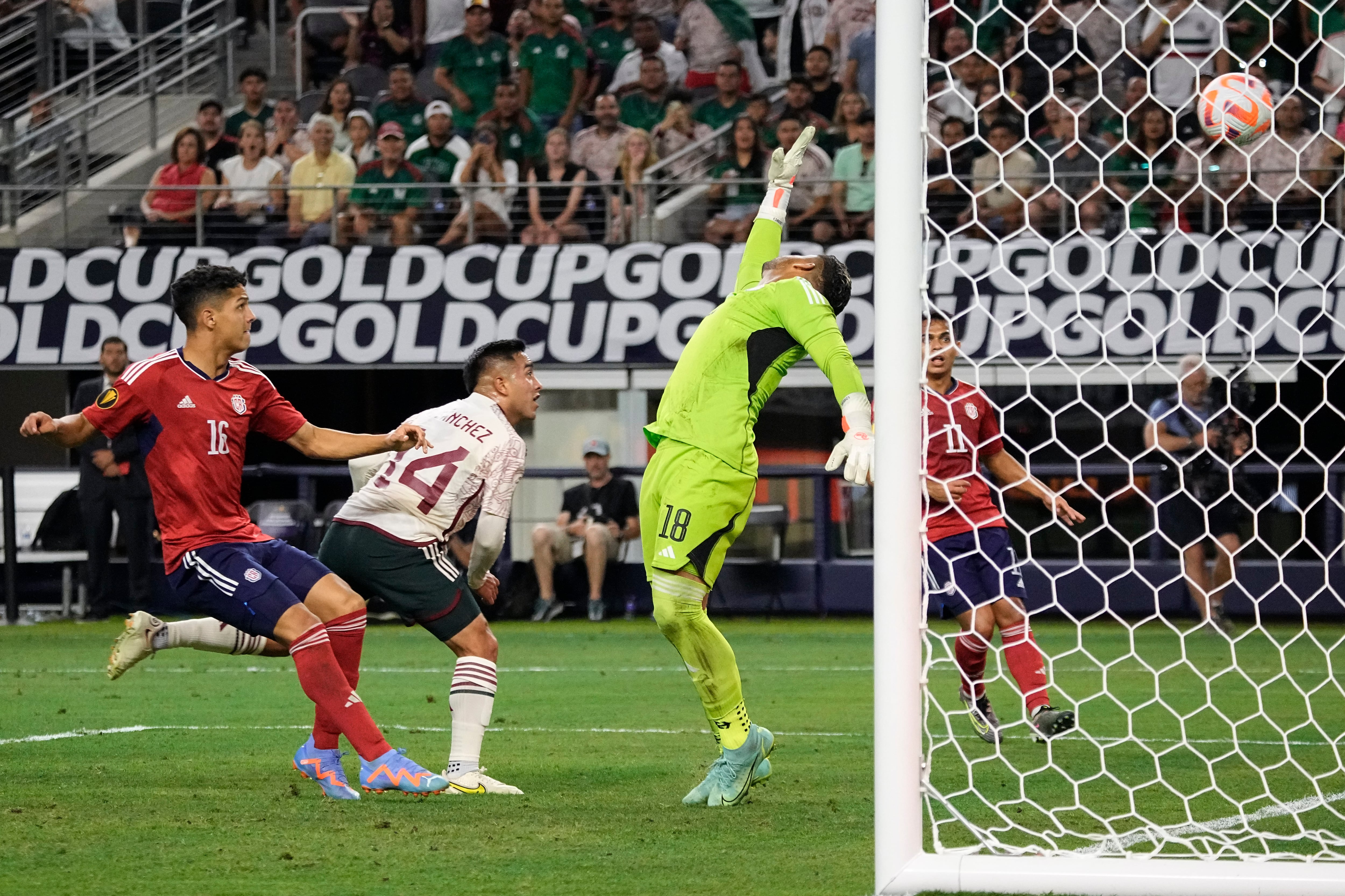 El delantero de México Érick Sánchez (14) golpea el balón y supera al arquero de Costa Rica Kevin Chamorro (18) para anotar un gol durante la segunda mitad de los cuartos de final de fútbol de la Copa Oro de CONCACAF, el sábado 8 de julio de 2023, en Arlington, Texas. (Foto AP/Sam Hodde)