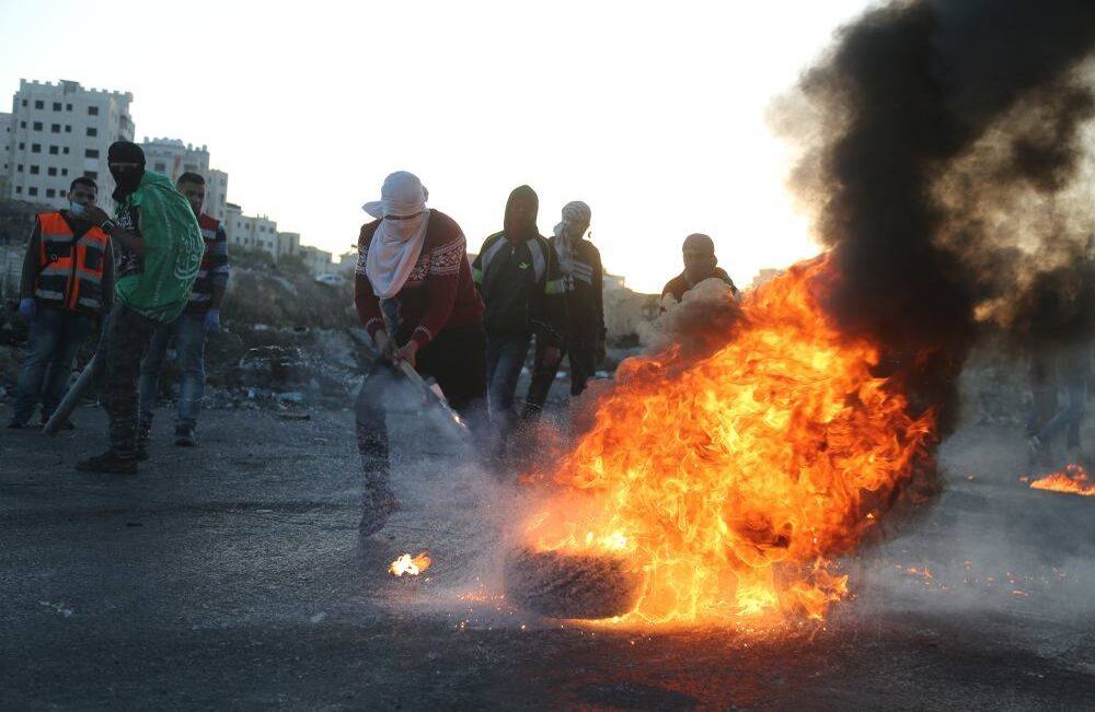 . Un grupo reunido cerca del punto de control de Beit El en la ciudad de Ramallah en Cisjordania protestó por la decisión del presidente estadounidense Donald Trump de reconocer a Jerusalén como "la capital de Israel". Issam Rimawi - Anadolu Ajansi )