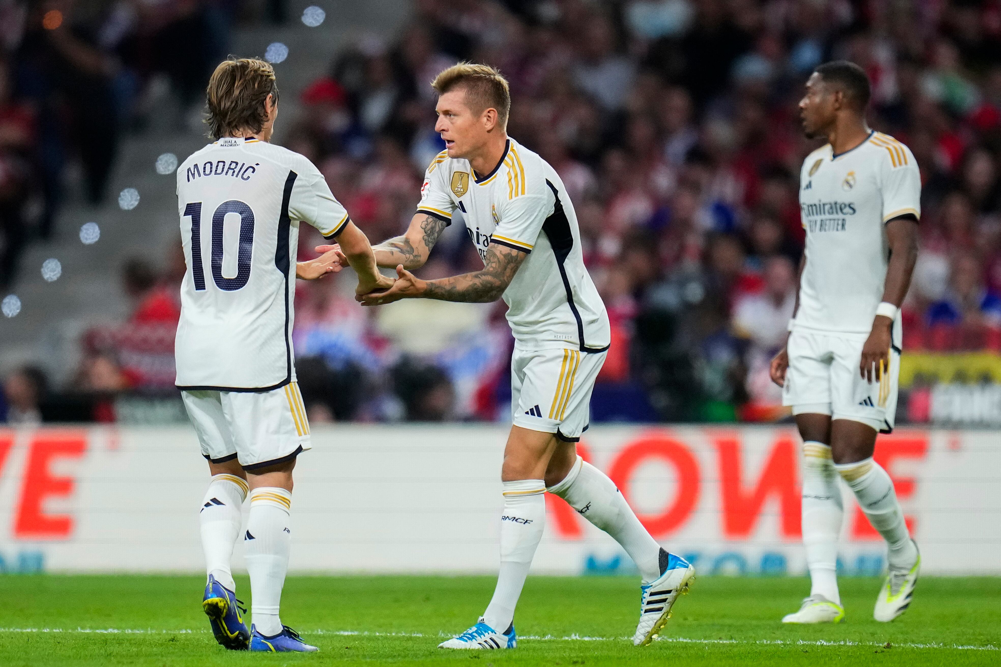 Toni Kroos, centro, del Real Madrid, celebra con su compañero Luka Modric después de anotar el primer gol de su equipo durante el partido de fútbol de la Liga española entre el Atlético de Madrid y el Real Madrid en el estadio Metropolitano de Madrid, el domingo 24 de septiembre de 2023. (Foto AP/Manu Fernández)