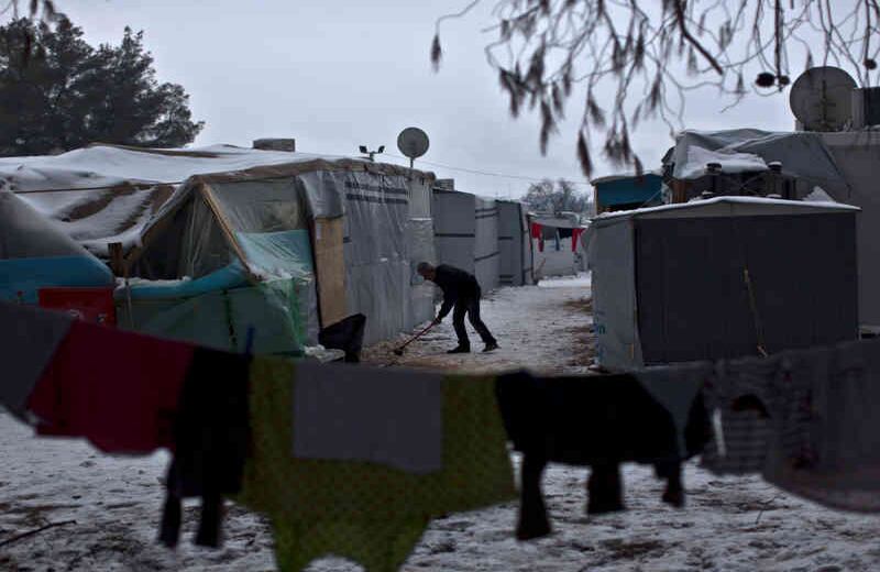 Un refugiado limpia su tienda de campaña a 80 kilómetros de Atenas. Foto: Muhammed Muheisen / AP   