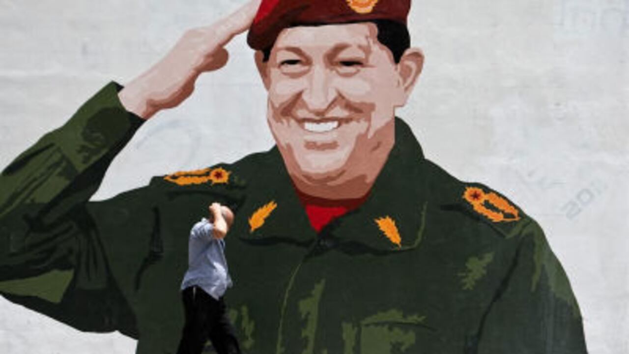 n hombre camina frente a un mural pintado con la imagen del presidente de Venezuela, Hugo Chávez, el sábado, en las calles de Caracas (Venezuela).