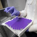 Un trabajador sostiene un frasco de una vacuna ficticia durante el entrenamiento sobre cómo se transportará y almacenará la vacuna contra el coronavirus (COVID-19) en el Centre Hospitalier Universitaire Ambroise Pare en Mons, Bélgica, el jueves 17 de diciembre de 2020. Foto: Benoit Doppagne, Pool vía AP.