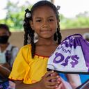 La niña guajira Maité sostiene una tula elaborada con material publicitario de WOM.