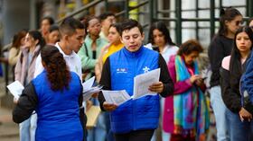 Un funcionario del Sena en compañía de personas que buscan empleo, en Bogotá