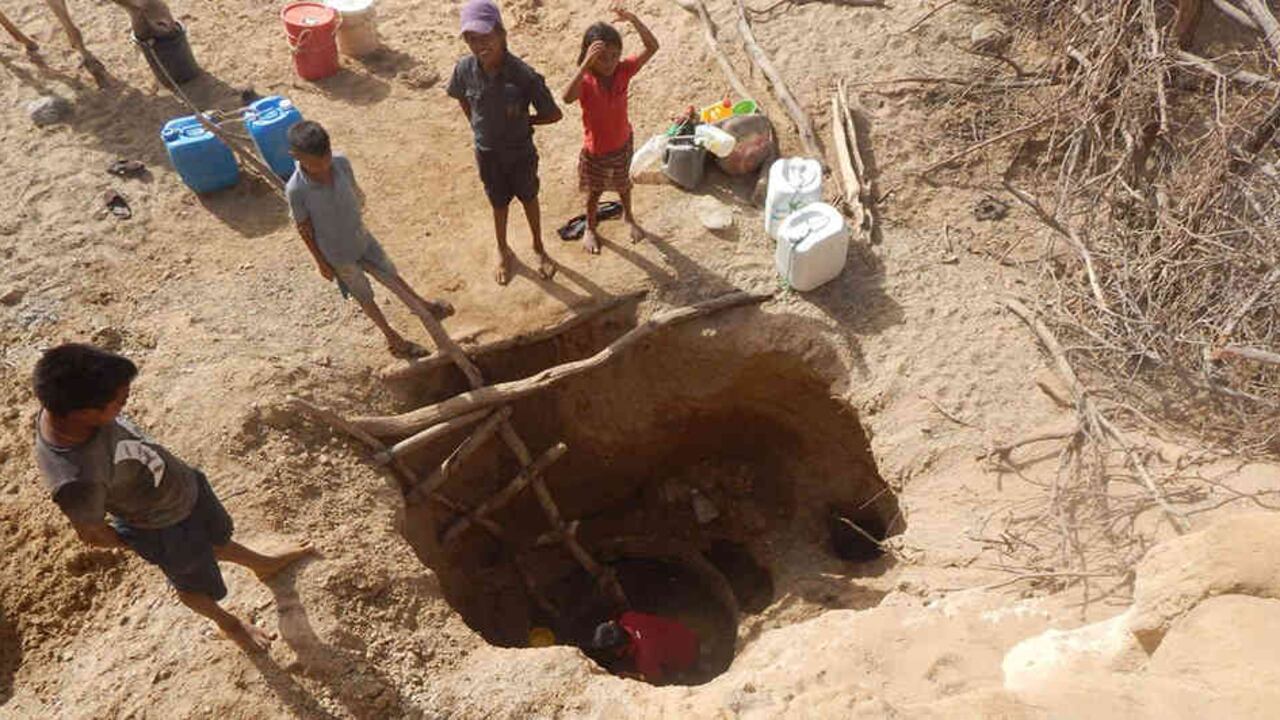 Un grupo de menores sacan agua de un pozo en mitad del desierto guajiro colombiano.