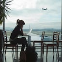 Mujer consultando su computador mientras aguarda en un aeropuerto - Imagen de referencia