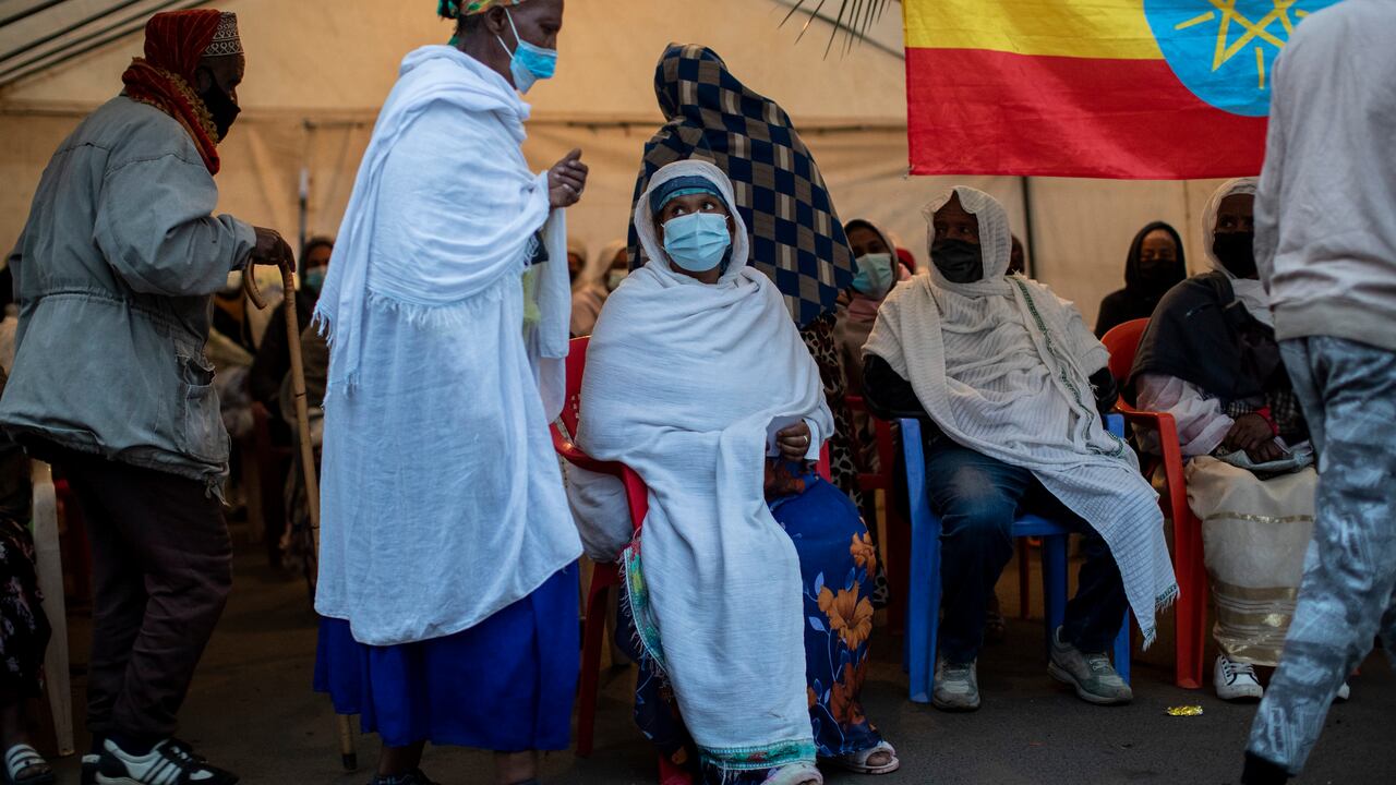 Etíopes haciendo fila para votar junto a una bandera nacional en las elecciones generales, en un centro electoral en la capital, Adís Abeba, el lunes 21 de junio de 2021. (Foto: AP/Ben Curtis)