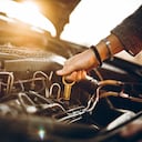 Woman checking car oil, close up.