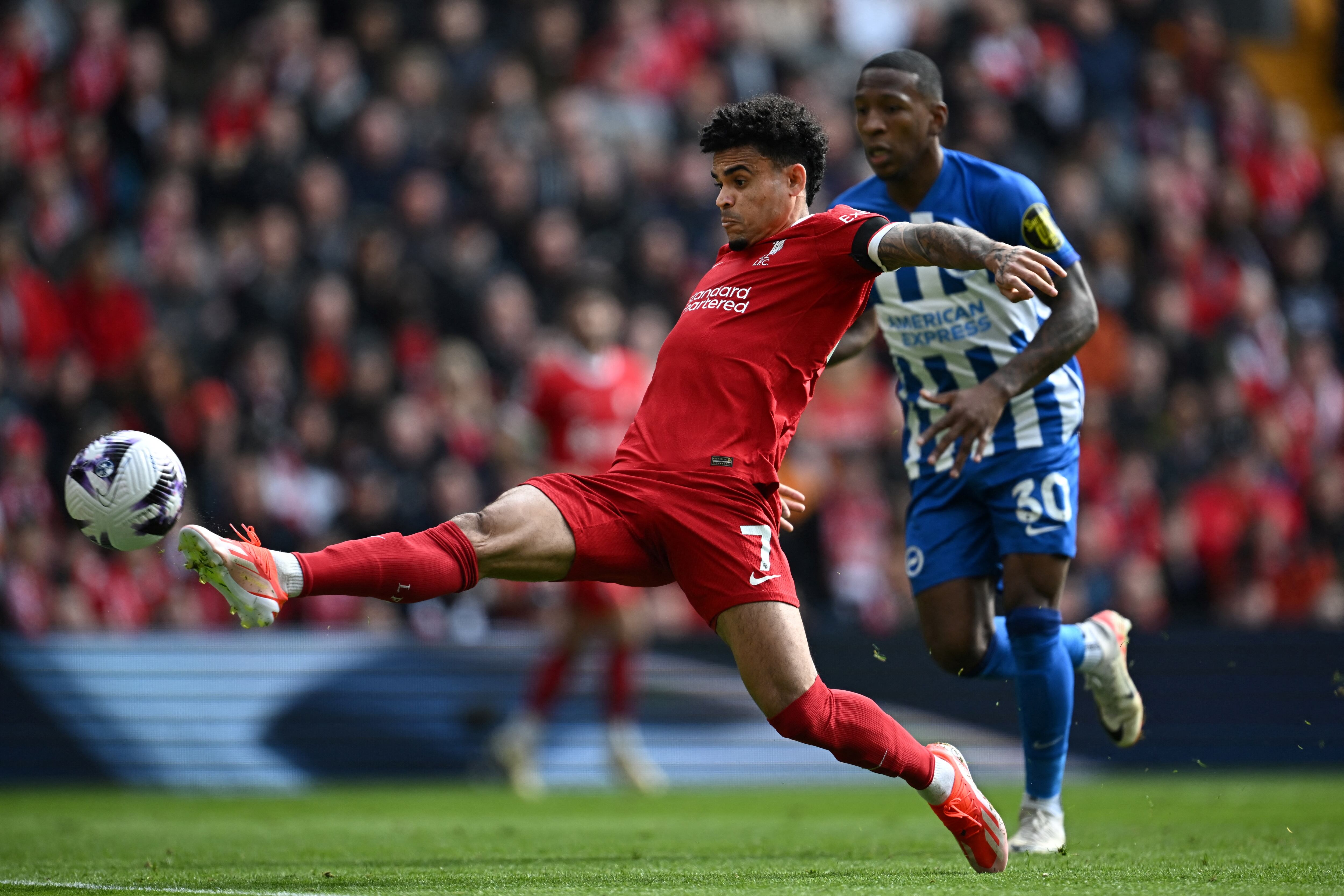 Liverpool's Colombian midfielder #07 Luis Diaz shoots and scores his team first goal during the English Premier League football match between Liverpool and Brighton and Hove Albion at Anfield in Liverpool, north west England on March 31, 2024. (Photo by Paul ELLIS / AFP) / RESTRICTED TO EDITORIAL USE. No use with unauthorized audio, video, data, fixture lists, club/league logos or 'live' services. Online in-match use limited to 120 images. An additional 40 images may be used in extra time. No video emulation. Social media in-match use limited to 120 images. An additional 40 images may be used in extra time. No use in betting publications, games or single club/league/player publications. /
