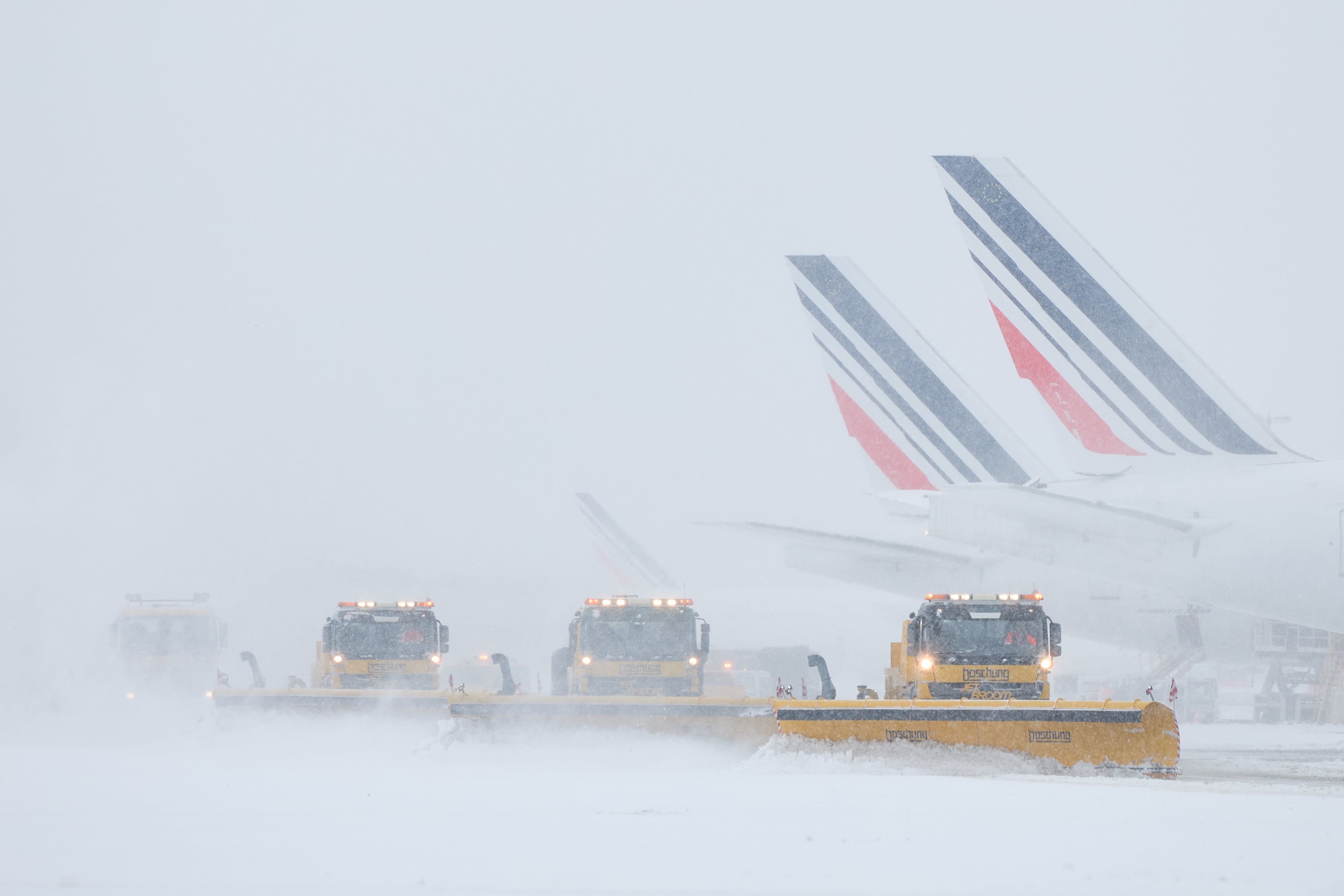 Aviones de Air France en la pista mientras las máquinas quitanieves limpian las pistas tras las fuertes nevadas que provocaron la cancelación de vuelos en el aeropuerto de Orly, al sur de París, el 7 de enero de 2026.