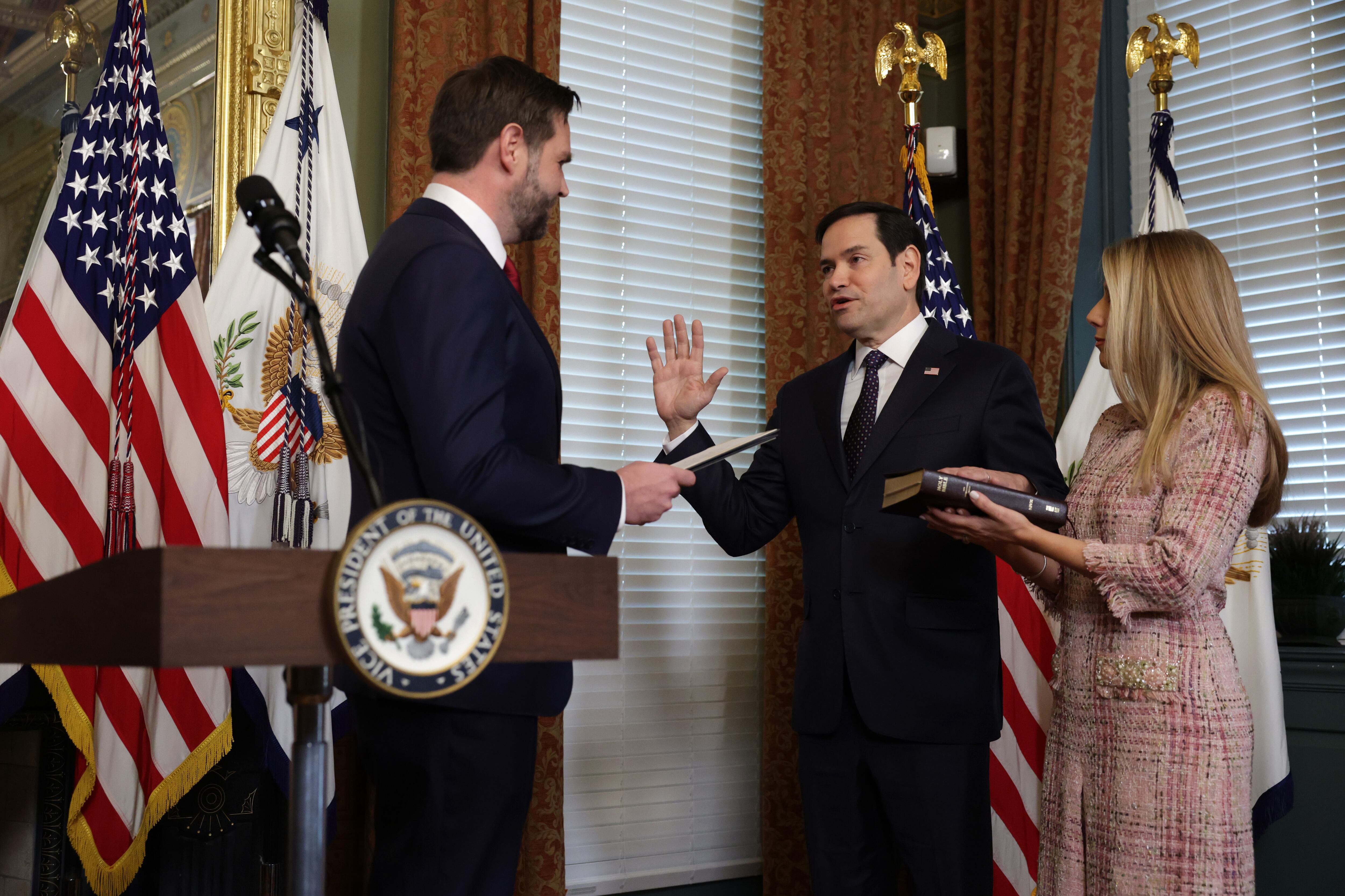 El ex senador estadounidense Marco Rubio (R-FL) (2do. Izq.) presta juramento ante el vicepresidente J.D. Vance (L) mientras su esposa Jeanette Dousdebes Rubio (R) mira durante una ceremonia de juramento en La oficina ceremonial del vicepresidente en el edificio de oficinas ejecutivas de Eisenhower el 21 de enero de 2025 en Washington, DC.