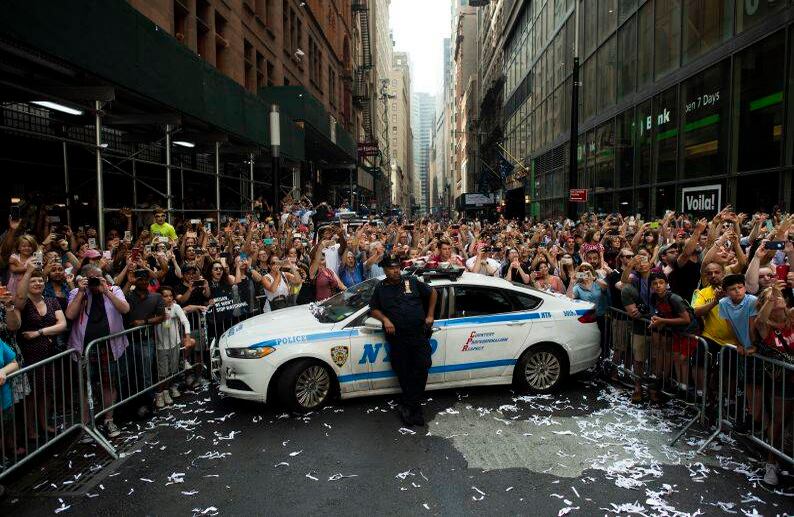Los fanáticos aplauden a los miembros del equipo femenino de EE. UU., ganador de la Copa Mundial mientras participan en un desfile el 10 de julio de 2019 en Nueva York. Decenas de miles de fanáticos están listos para llenar las calles de Nueva York para saludar al equipo femenino de Estados Unidos que ganó la Copa del Mundo. (Foto de Johannes EISELE / AFP)