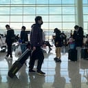 Los pasajeros con máscaras faciales para protegerse contra la propagación del coronavirus se alinean en una puerta de embarque en el Aeropuerto Internacional Wuhan Tianhe en Wuhan, en la provincia de Hubei, en el centro de China.