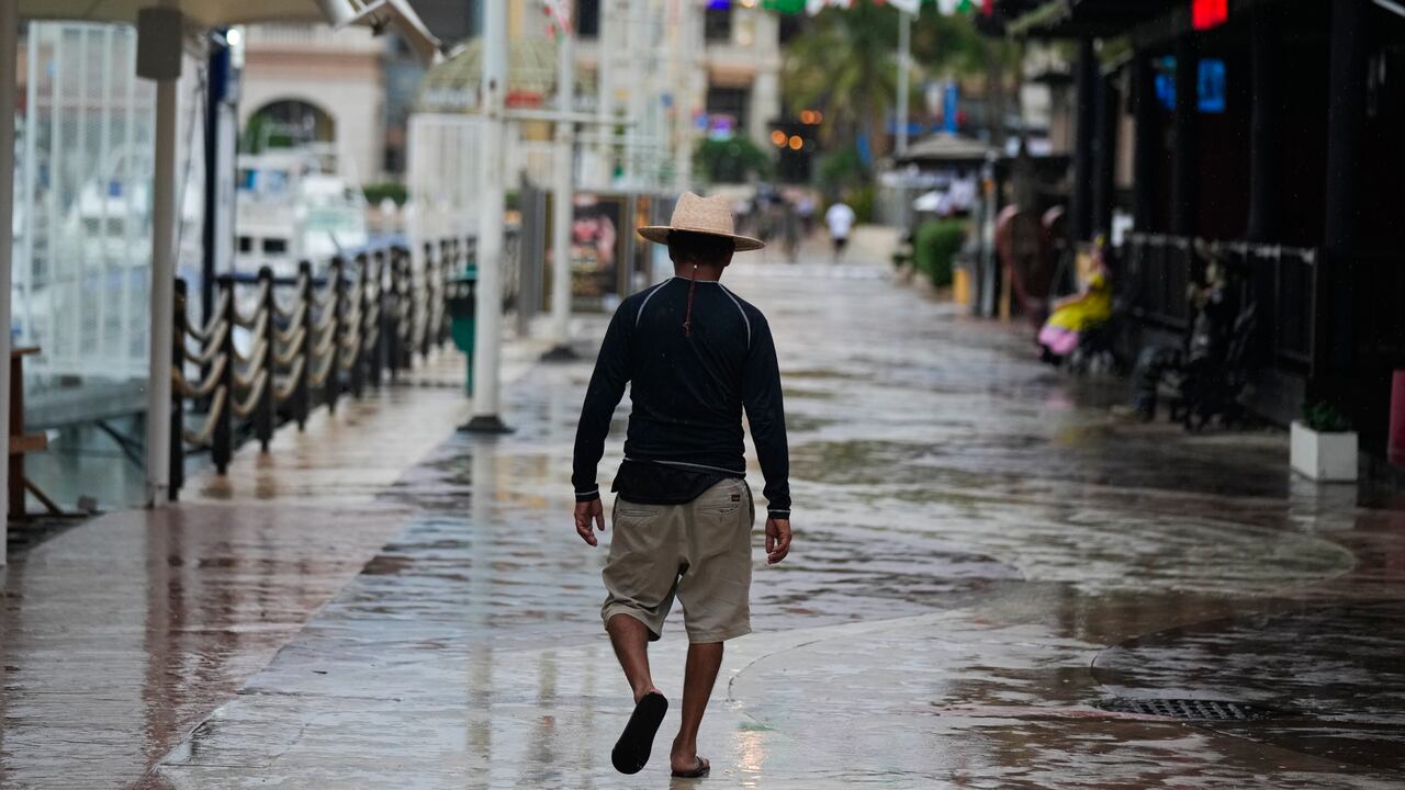 Un hombre camina en medio de tiendas y restaurantes cerrados debido a la proximidad del huracán Norma, el viernes 20 de octubre de 2023, en Cabo San Lucas, México. (AP Foto/Fernando Llano)