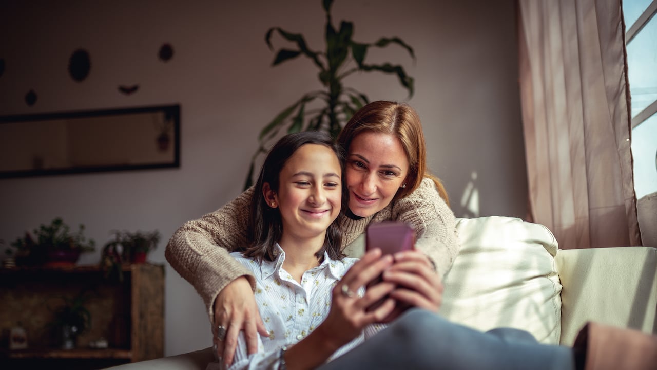 Madre e hija usando un celular