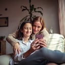 Madre e hija usando un celular