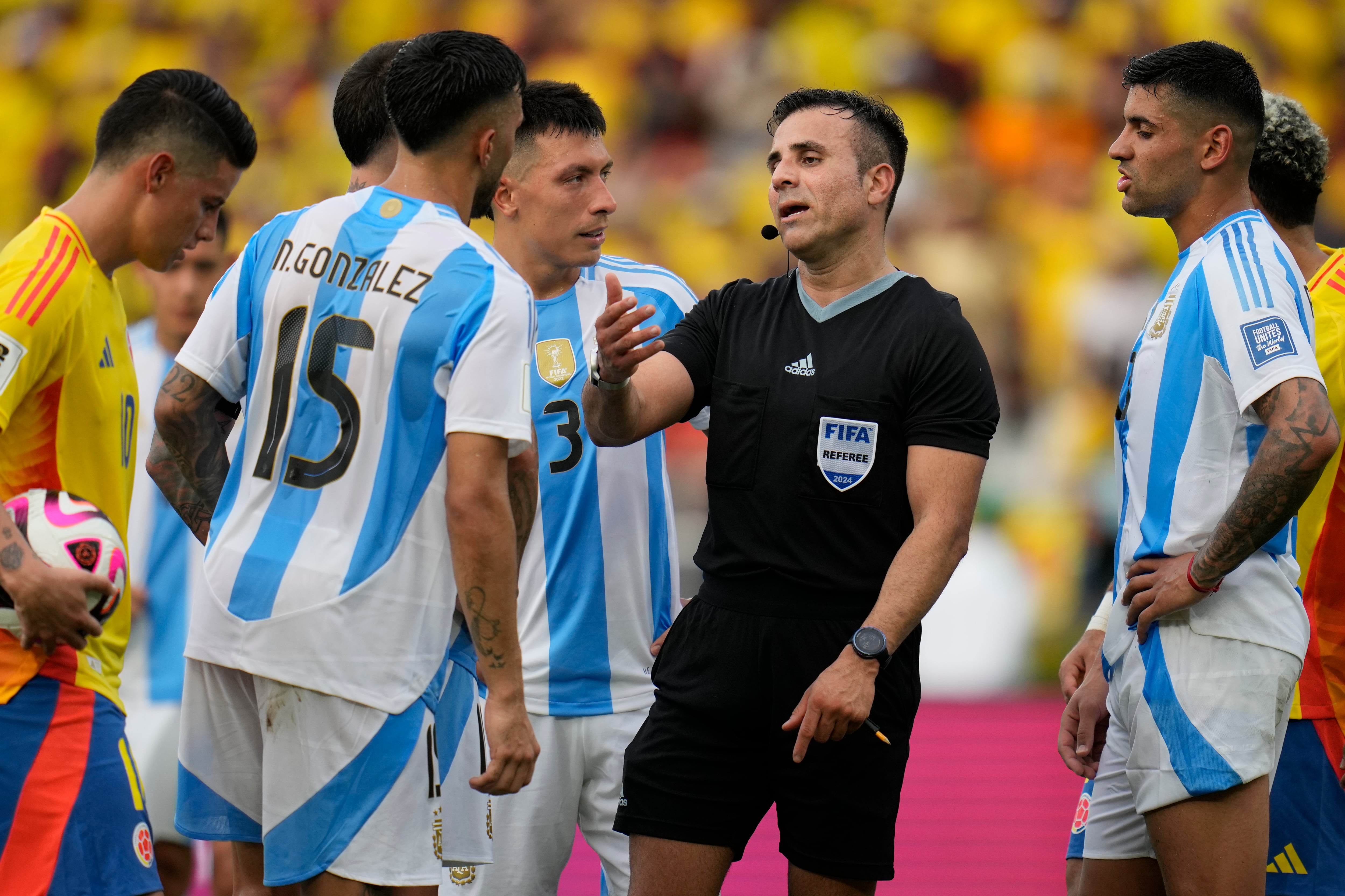 Referee Piero Maza talks to Argentina's Nicolas Gonzalez (15) during a qualifying soccer match against Colombia for the FIFA World Cup 2026 at the Metropolitano Roberto Melendez stadium in Barranquilla, Colombia, Tuesday, Sept. 10, 2024. (AP Photo/Ricardo Mazalan)