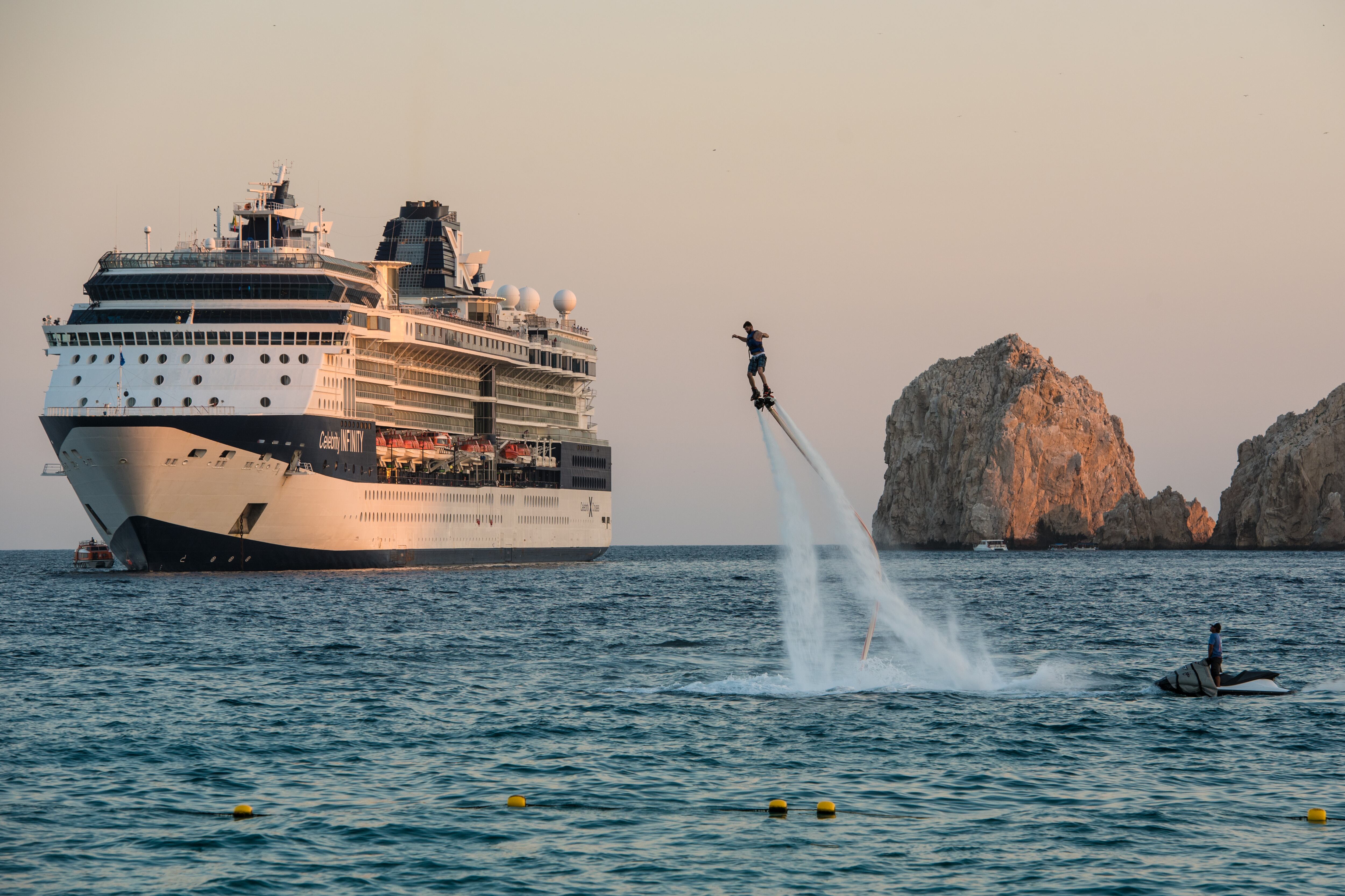 Un piloto de flyboard se eleva por el aire en Cabo San Lucas frente a un crucero anclado.