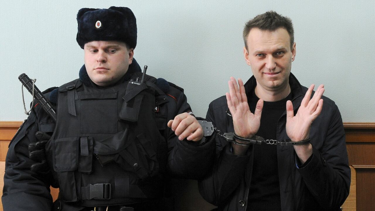 El líder de la oposición rusa Alexei Navalny, derecha, posa para la prensa mientras está sentado esposado en un tribunal en Moscú, Rusia, el 30 de marzo de 2017. La agencia penitenciaria de Rusia dice que el líder de la oposición encarcelado Alexei Navalny ha muerto.