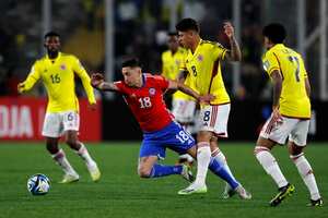 Jorge Carrascal disputando un balón con jugador chileno.