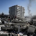 La gente espera mientras los rescatistas realizan operaciones de búsqueda entre los escombros de los edificios derrumbados en Kahramanmaras, el 9 de febrero de 2023. (Foto de OZAN KOSE / AFP)