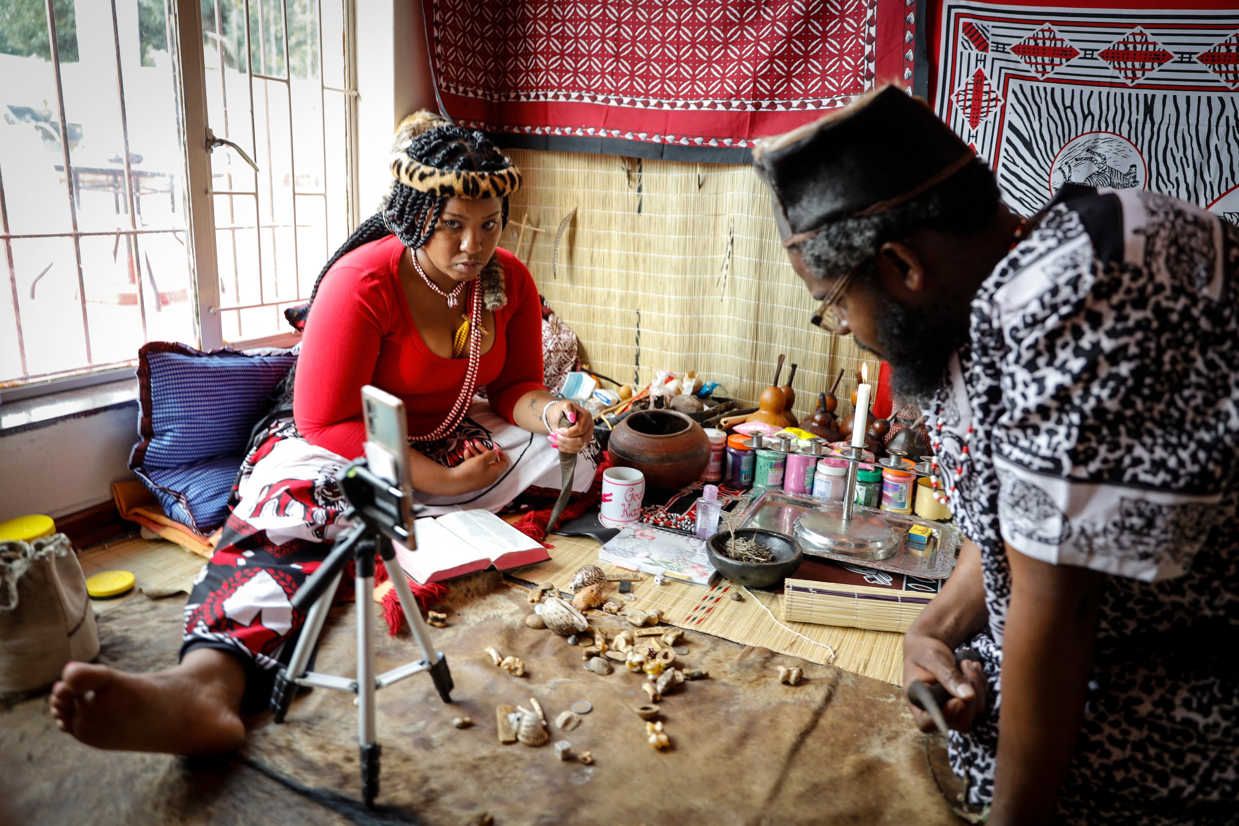 Traditional healer Gogo Kamo (L), does an online consultation with a client in her consultation room in Kempton Park, South Africa on April 16, 2021. - Known as "sangomas" in Zulu language, traditional healers are qualified herbalists, councillors and community mediators as well as diviners.