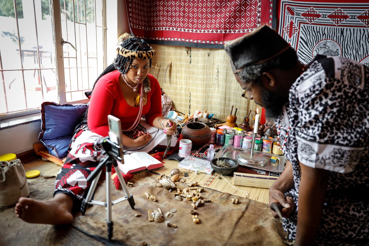 Traditional healer Gogo Kamo (L), does an online consultation with a client in her consultation room in Kempton Park, South Africa on April 16, 2021. - Known as "sangomas" in Zulu language, traditional healers are qualified herbalists, councillors and community mediators as well as diviners.