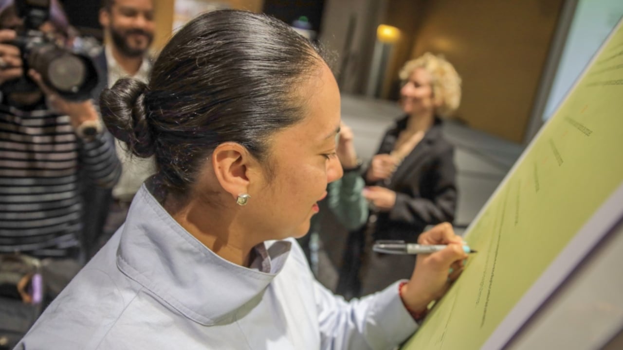 La secretaria de Movilidad, Deyanira Ávila, firmando el pacto para promover el buen parqueo en Bogotá.