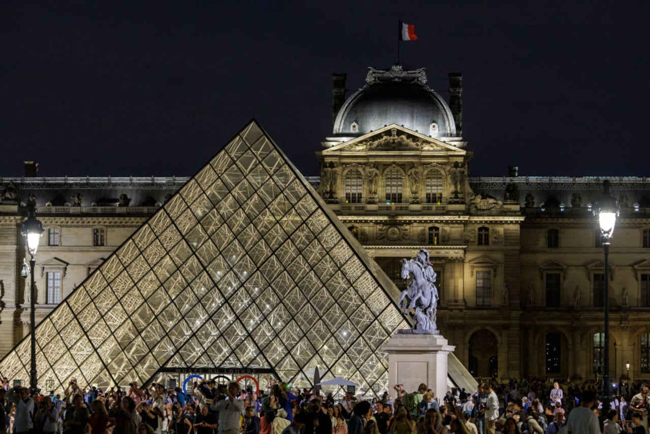 Los visitantes toman fotografías del Caldero Olímpico que se encuentra en los Jardines de las Tullerías desde la Pirámide del Louvre el 7 de agosto de 2024 en París, Francia. (Foto de Luc Castel/Getty Images