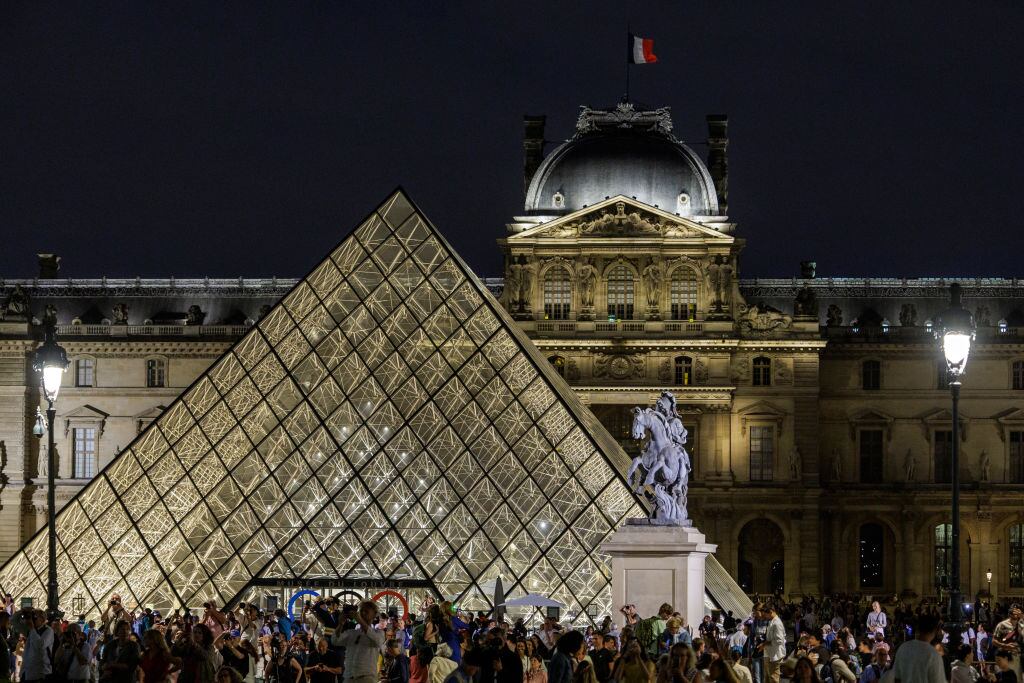 Los visitantes toman fotografías del Caldero Olímpico que se encuentra en los Jardines de las Tullerías desde la Pirámide del Louvre el 7 de agosto de 2024 en París, Francia. (Foto de Luc Castel/Getty Images