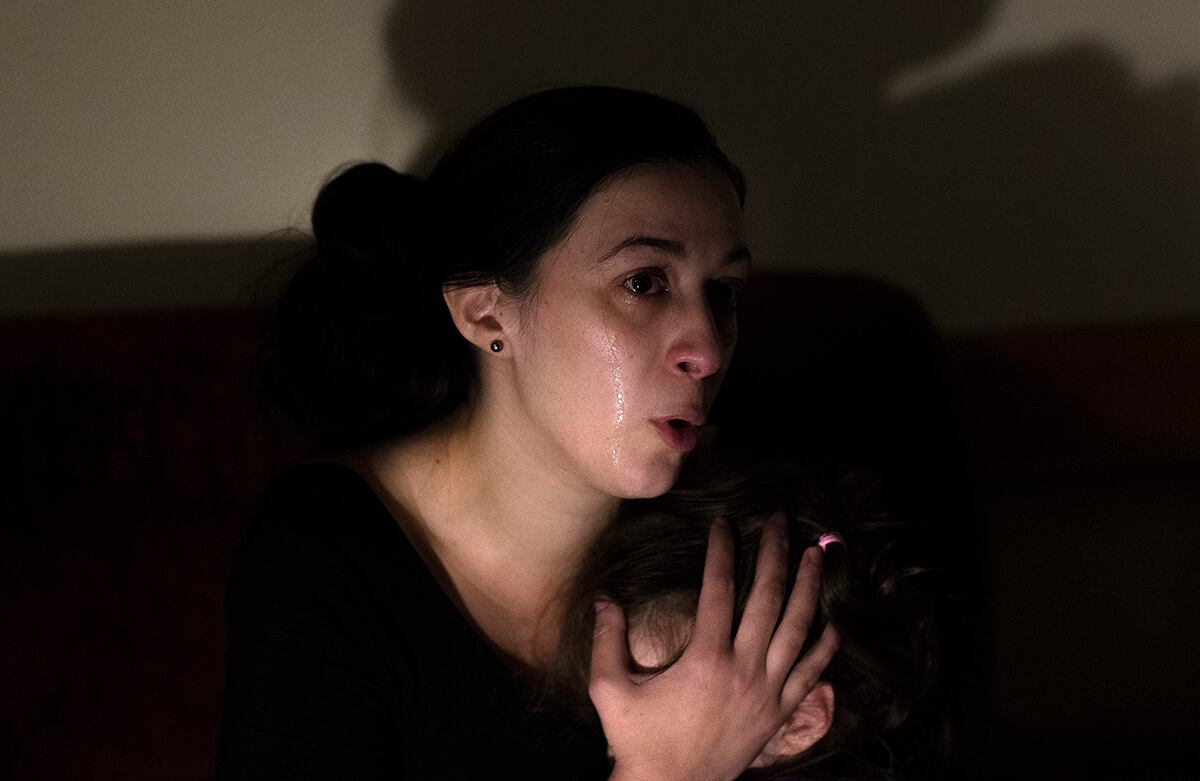 Esther Giménez Giménez, de 31 años de edad, cubre la cara de su hija mientras la entrevista un canal de la televisión española. La mujer, su esposo y sus dos hijas, que viven del subsidio que el gobierno español les brinda, lograron que el desalojo de su apartamento fuera pospuesto hasta el 9 de abril del próximo año. (AP)