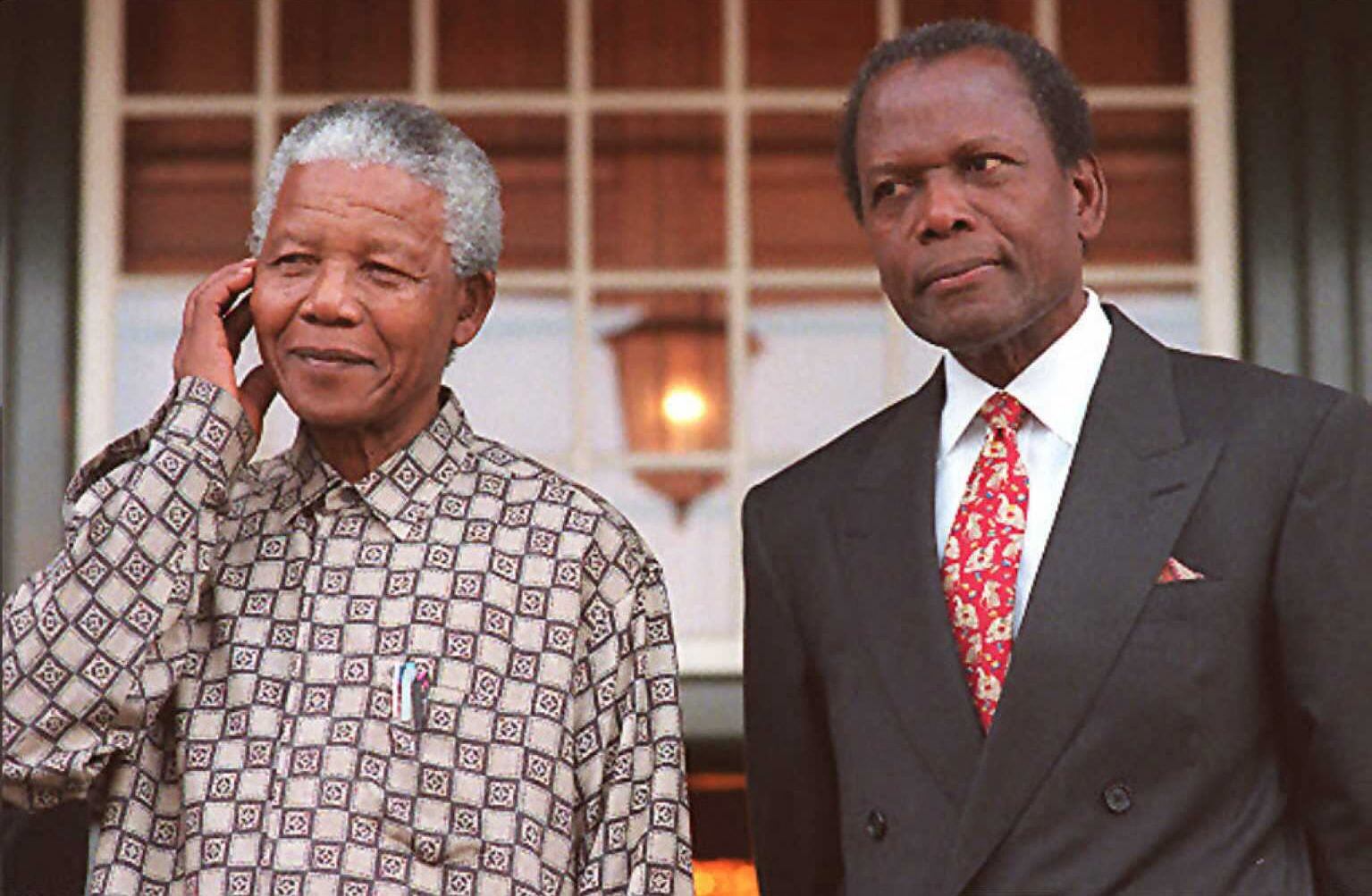 (ARCHIVOS) En esta foto de archivo tomada el 16 de mayo de 1996, el presidente Nelson Mandela (izq.) Y el actor estadounidense Sidney Poitier posan para las cámaras en Tuinhuis en Ciudad del Cabo. - Sidney Poitier, la primera gran estrella de cine negra de Hollywood, ha muerto, dijo el viceprimer ministro de las Bahamas el 7 de enero de 2022. Poitier, que tenía la doble nacionalidad estadounidense y bahameña, era "un icono, un héroe, un mentor, un luchador, un tesoro nacional ", dijo el viceprimer ministro Chester Cooper en su página oficial de Facebook. (Foto de Anna ZIEMINSKI / AFP)