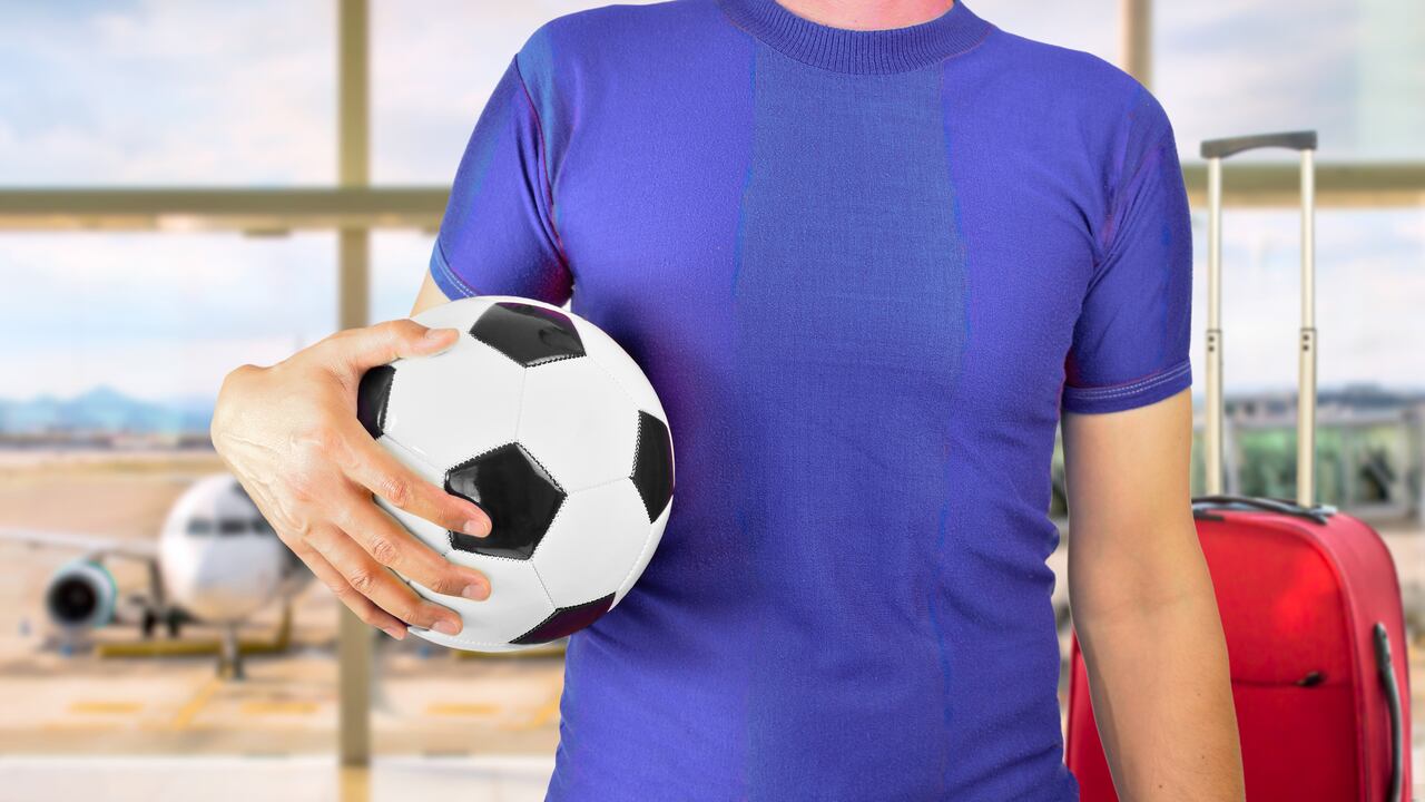 Foto de referencia de un joven con un balón de fútbol en una aeropuerto
