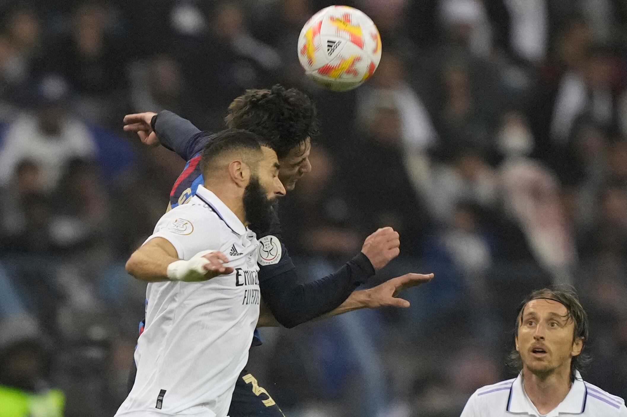 Real Madrid's Karim Benzema, front. And Barcelona's Gavi jump for the ball during the final of the Spanish Super Cup between Barcelona and Real Madrid in Riyadh, Saudi Arabia, Sunday, Jan. 16, 2023. (AP Photo/Hussein Malla)
