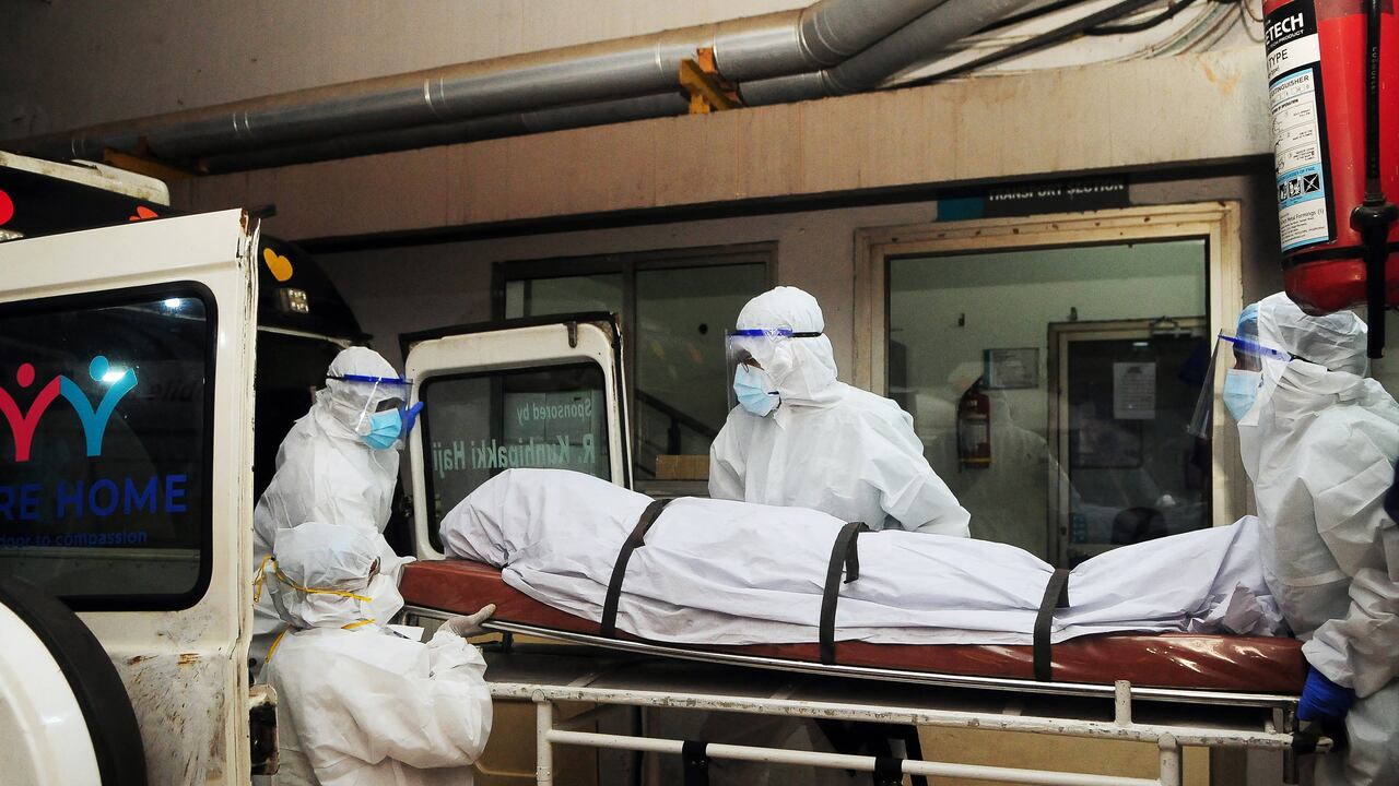 En esta fotografía tomada el 12 de septiembre de 2023, trabajadores sanitarios con equipo de protección mueven el cuerpo de una persona que murió a causa de una infección por el virus Nipah en un hospital privado de Kozikode, en el estado indio de Kerala.