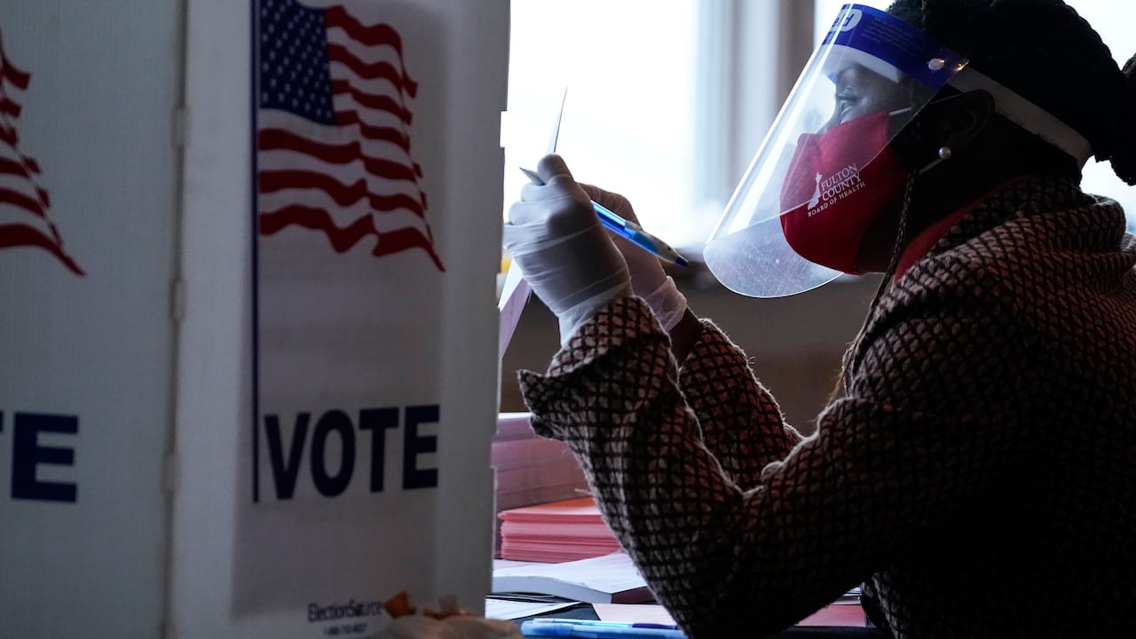 Una trabajadora electoral habla con un votante antes de que deposite su boleta el 3 de noviembre del 2020 en Atlanta. (AP Foto/Brynn Anderson)