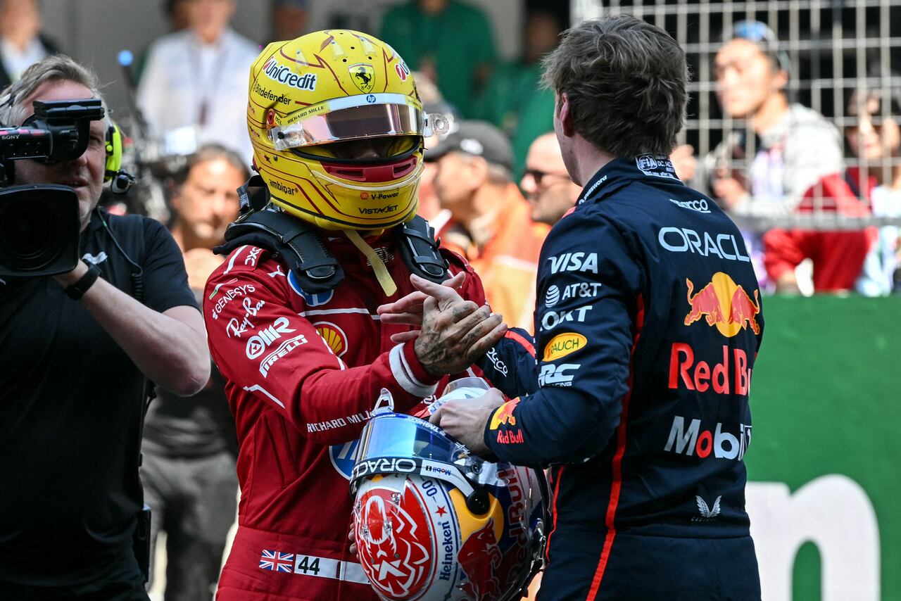 Sprint race winner Ferrari's British driver Lewis Hamilton greets third placed Red Bull Racing's Dutch driver Max Verstappen (R) after the sprint race of the Formula One Chinese Grand Prix at the Shanghai International Circuit in Shanghai on March 22, 2025. (Photo by GREG BAKER / AFP)