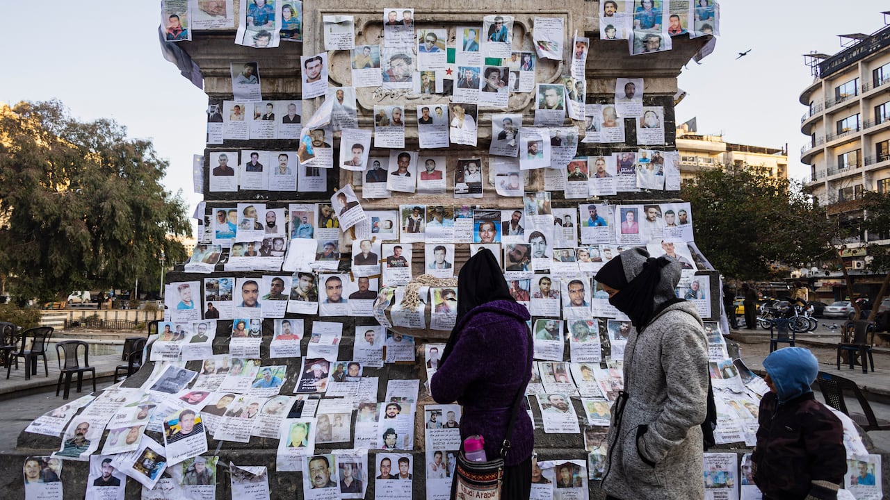 Carteles de personas desaparecidas cuelgan de un monumento en el centro de la plaza Marjeh en Damasco el 26 de diciembre de 2024. (Foto de Sameer Al-DOUMY / AFP)