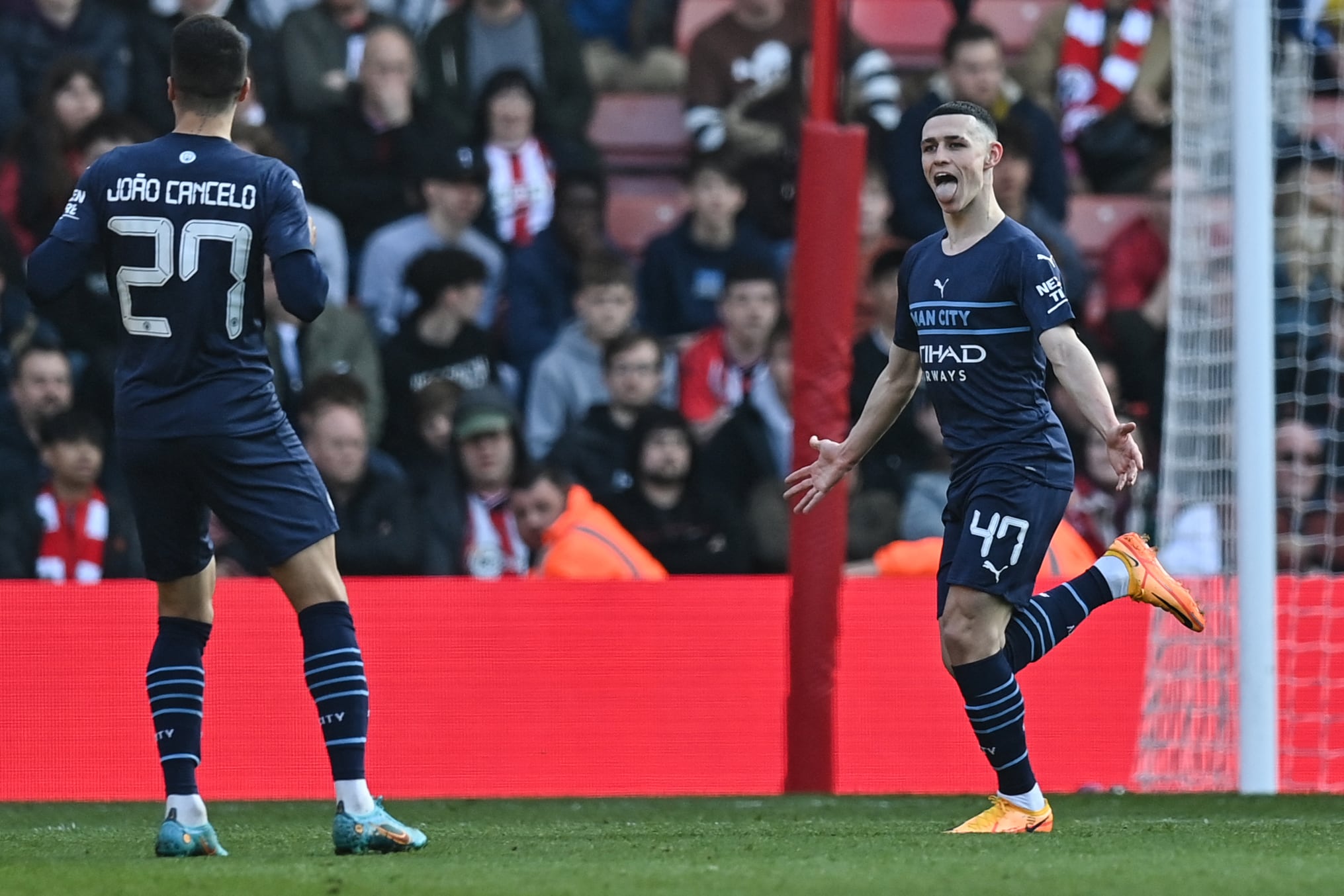 El mediocampista inglés del Manchester City Phil Foden (R) celebra con sus compañeros de equipo después de marcar el tercer gol de su equipo durante el partido de fútbol de cuartos de final de la Copa FA inglesa entre Southampton y Manchester City en el St Mary's Stadium en Southampton, sur de Inglaterra, el 20 de marzo de 2022. (Foto por Glyn KIRK / AFP) / RESTRINGIDO AL USO EDITORIAL. No se utiliza con audio, video, datos, listas de dispositivos, logotipos de clubes/ligas o servicios 'en vivo' no autorizados. Uso en línea durante el partido limitado a 120 imágenes. Se pueden usar 40 imágenes adicionales en tiempo extra. Sin emulación de vídeo. El uso de las redes sociales durante el partido está limitado a 120 imágenes. Se pueden usar 40 imágenes adicionales en tiempo extra. No se utiliza en publicaciones de apuestas, juegos o publicaciones de un solo club/liga/jugador. /