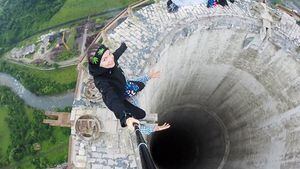 Esta joven arriesga su vida para tomarse una fotografía en la punta de una chimenea de 180 metros de altura en desuso en Rumania.