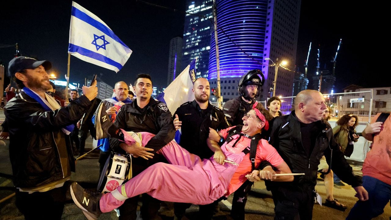 Un hombre detenido reacciona mientras la policía lo lleva durante una manifestación contra la reforma judicial del gobierno de coalición nacionalista de Israel, luego de un discurso televisado pronunciado por el primer ministro israelí Benjamin Netanyahu, en Tel Aviv