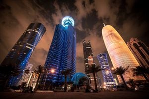 Rascacielos modernos futuristas que iluminan la noche en el paseo de la cornisa en la ciudad capital de Doha, Qatar, Oriente Medio