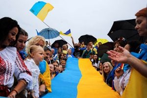 Los ucranianos que viven en Grecia sostienen una bandera nacional ucraniana mientras se reúnen para conmemorar el Día de la Independencia de Ucrania, en Atenas, Grecia, el 24 de agosto de 2022. Foto REUTERS/Costas Baltas