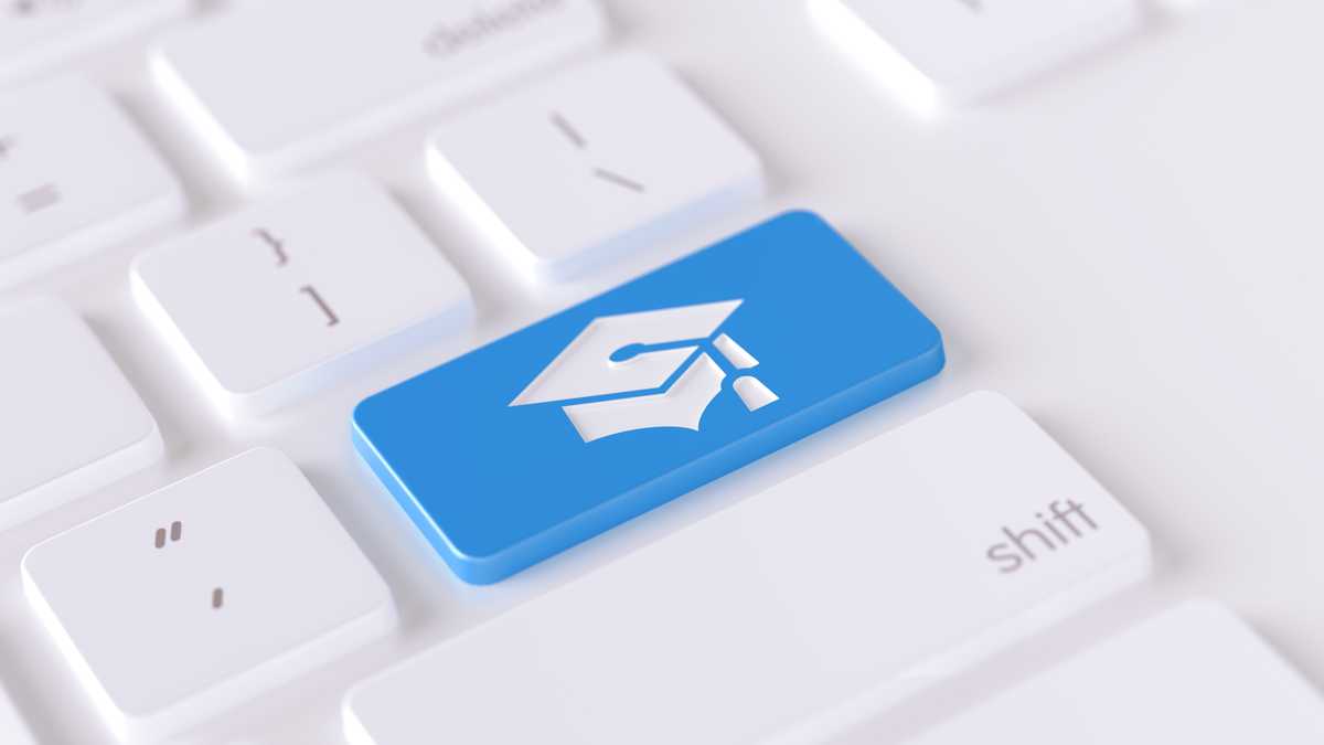 Icono de gorro de graduación escrito en un botón azul de un teclado de computadora. Composición horizontal con enfoque selectivo y espacio de copia. Vista de ángulo alto. Concepto de educación en línea.